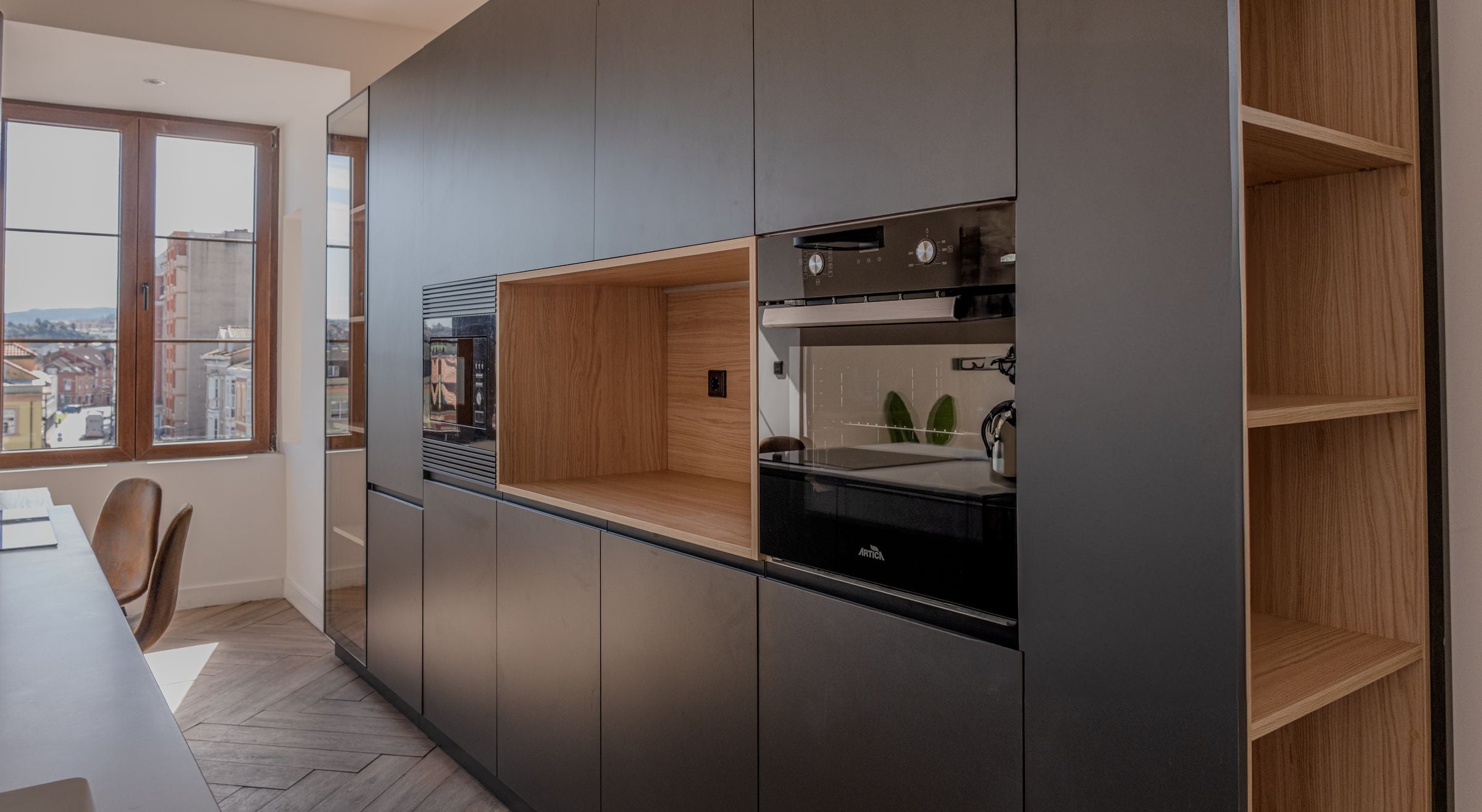 Cocina en tonos grafito con columnas integradas y vistas a la ciudad