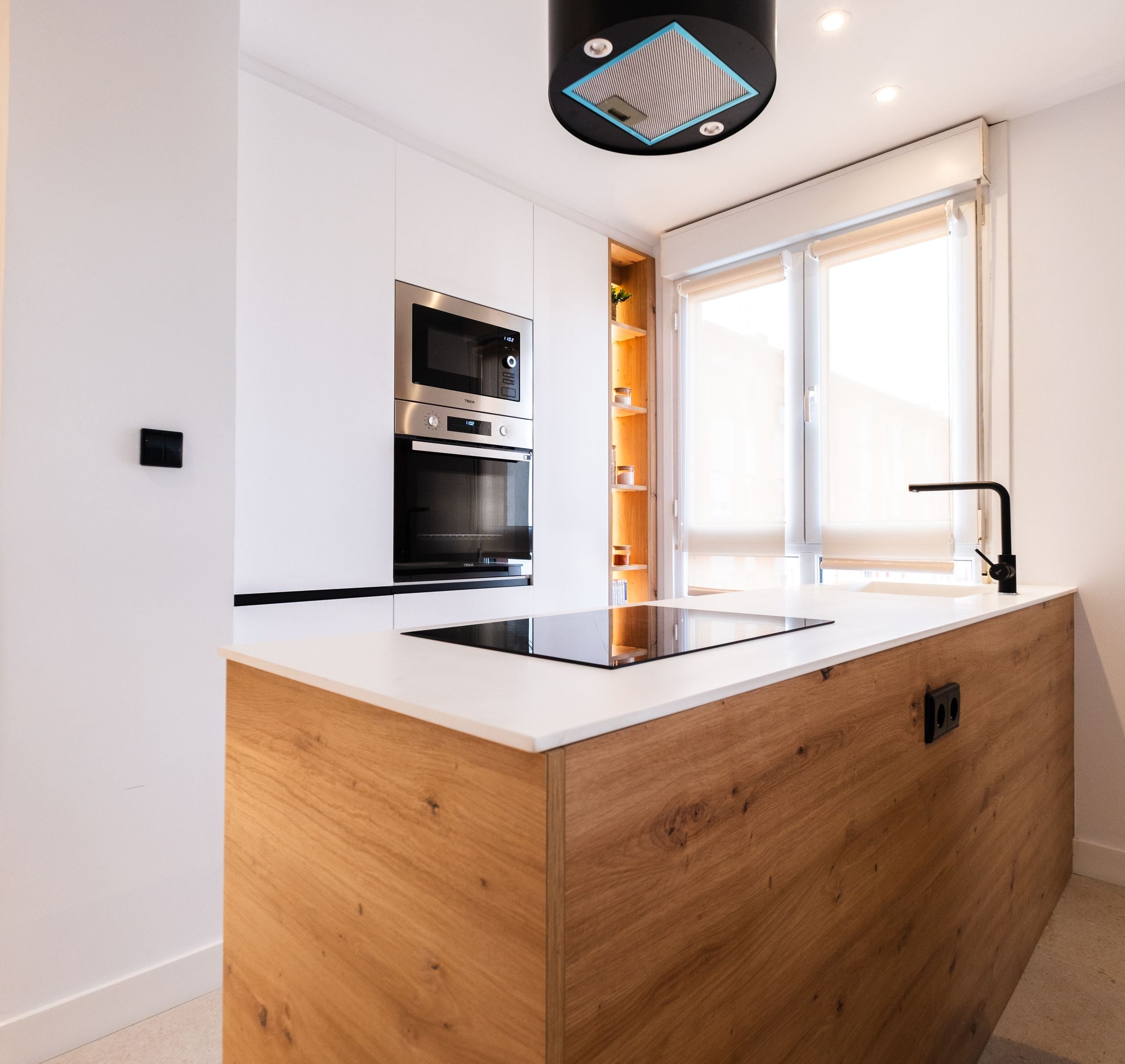 Cocina con isla en madera y encimera blanca