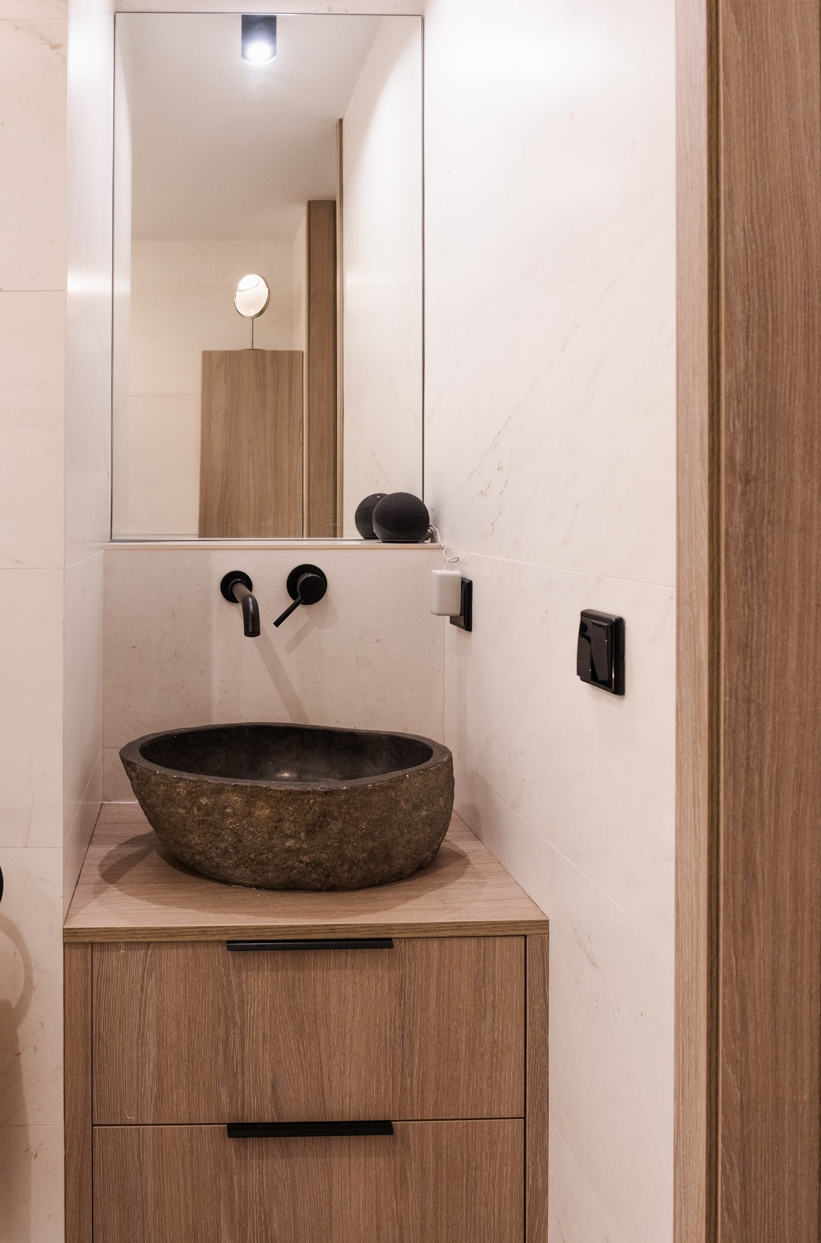 Aseo con lavabo de piedra natural sobre mueble de madera